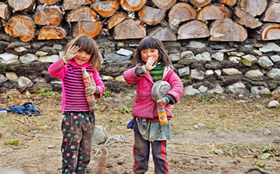 Zwei winkende fröhliche Mädchen in Bhutan