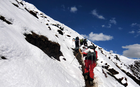 Trekkinggruppe wandert im Schnee aufwärts